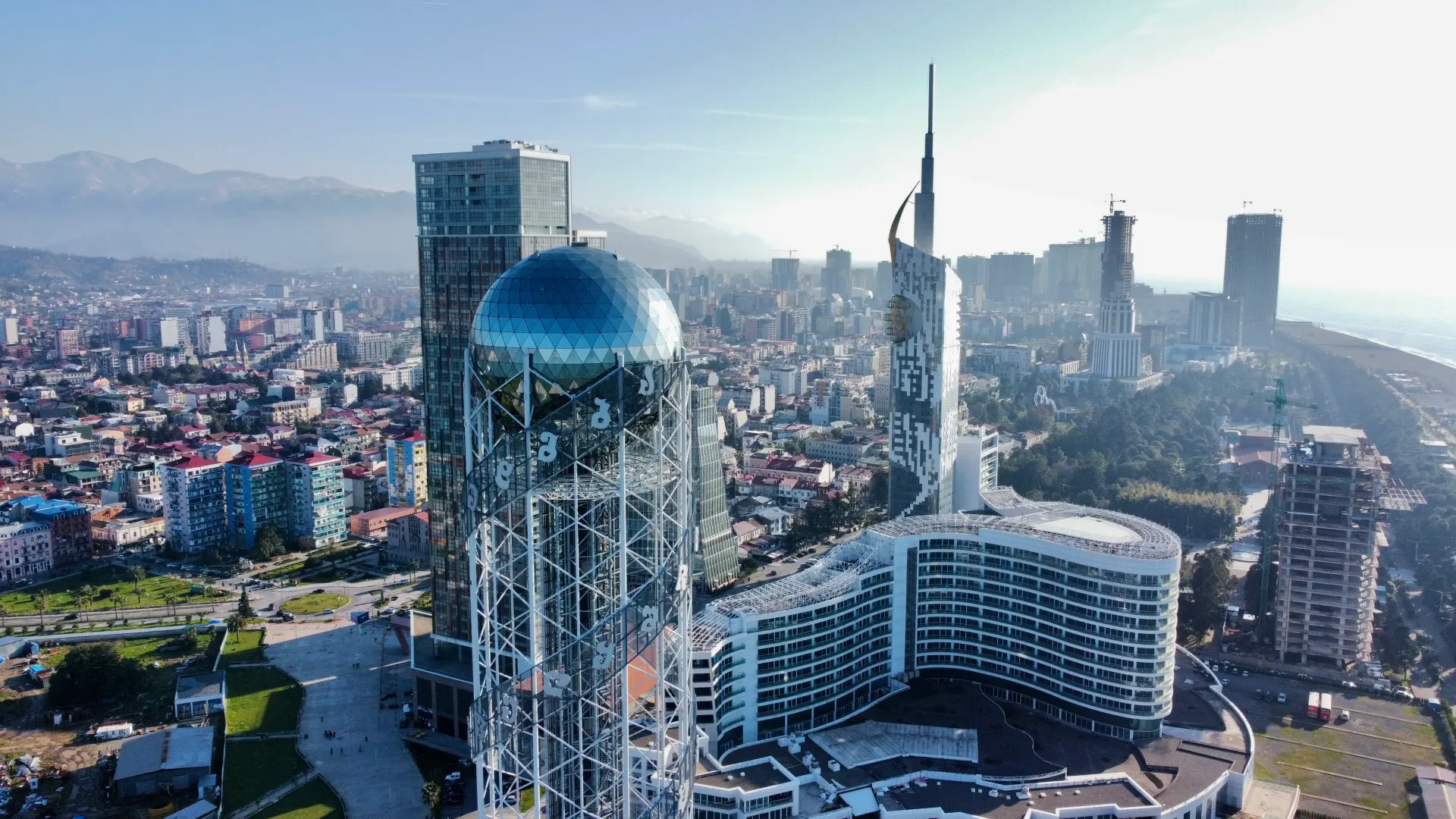 Batumi's Alphabet Tower and high-rises from above, mountains behind