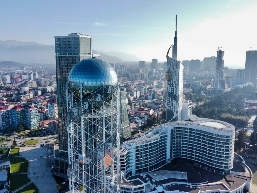Batumi's Alphabet Tower and high-rises from above, mountains behind