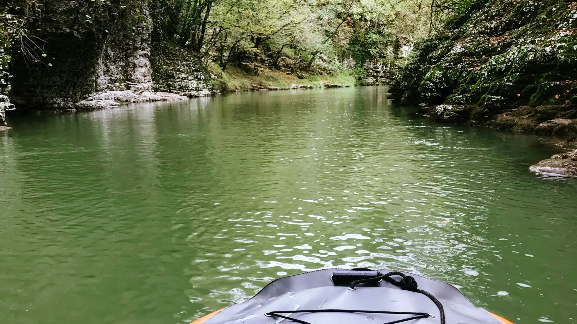 Нос надувной лодки на зелёной воде каньона Мартвили